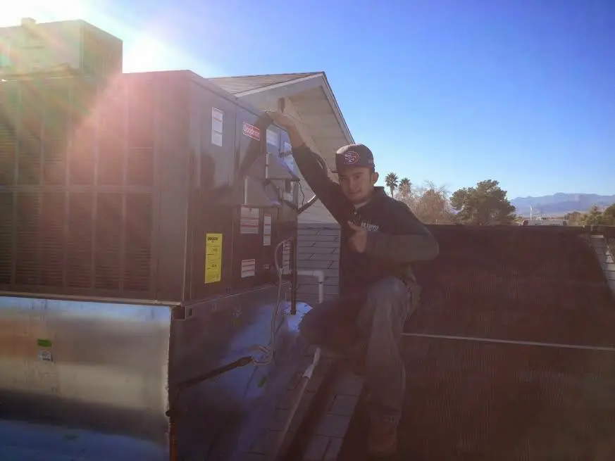 HVAC technician performing AC Tune-Up on a rooftop unit in Jerseyville